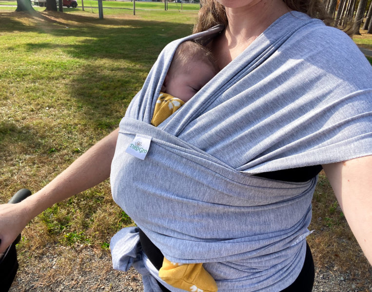 woman wearing newborn in daisy gro wrap