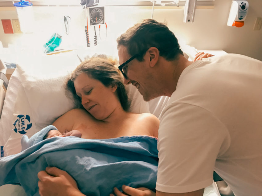 mother and father gaze at their newborn baby